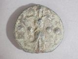 a coin with a face on it on a white surface