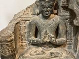 statue of a seated person on a stone throne with carvings