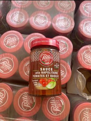 a jar of sauce sitting on top of a pile of packages
