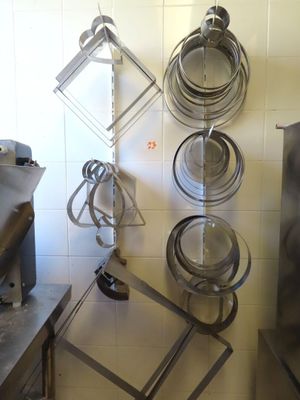 de nombreuses casseroles et poêles suspendues à une étagère dans la cuisine