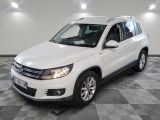 the white volkswagen tigua is parked in a clean room