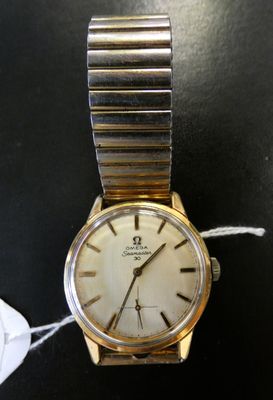 une montre en or avec un cadran blanc sur un fond noir