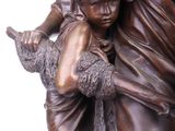bronze statue of a woman carrying a child on a horse
