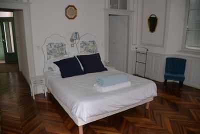 un lit blanc orné d'oreillers bleus, dans une chambre