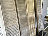 several wooden shutters are lined up against a wall in a room
