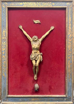 Christ en bois sculpté et doré dans son encadrement.