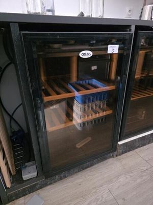 une porte vitrée derrière laquelle se trouvent tout un tas de bouteilles