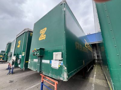 un gros camion vert garé sur un parking