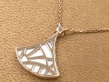 a close up of a silver pendant on a gold chain