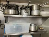 de nombreuses casseroles et poêles sur l'étagère de la cuisine