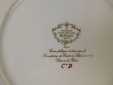 a white plate with a gold and red design on it