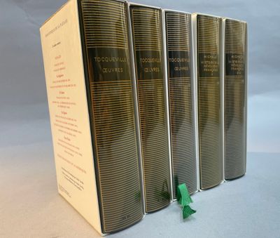 four books are lined up in a row on a white surface