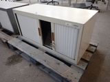 un conteneur blanc posé sur une palette dans un entrepôt
