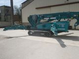 a blue crane that is parked in front of a building