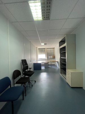 un long couloir avec des chaises et un bureau à l'intérieur