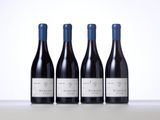 three bottles of red wine are lined up on a table