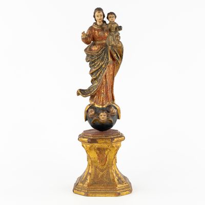 an image of a statue of a woman holding a child on top of a globe