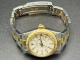 une montre-bracelet en argent et en or posée sur une table
