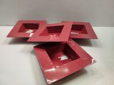 trois plateaux rouges posés sur une table blanche