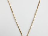 un collier en or avec une pièce de monnaie sur une chaîne
