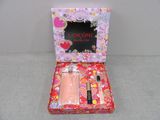 an image of a pink box containing two perfumes and a perfume brush
