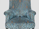 an upholstered chair with a blue and brown patterned upholstered back