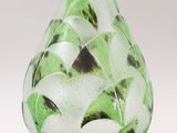 a glass vase with a green and white design on it
