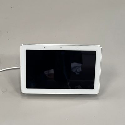 une tablette blanche posée sur une table, dont l'écran est noir