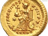 a gold coin with an image of a woman holding a sword