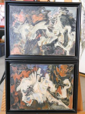 Deux tableaux représentant des chevaux sont exposés sur une table en bois
