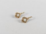 a pair of pearl earrings on a white surface
