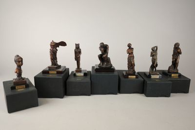 six figurines en bronze de tailles et de formes variées, posées sur des socles noirs