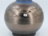 a silver vase with a blue lid sitting on a white surface