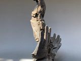 a sculpture of a bird sitting on top of a piece of wood