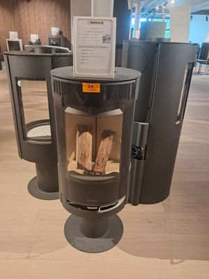 une cheminée au milieu d'une pièce où il y a beaucoup de bois