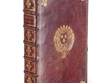an old book with a gold emblem on the cover