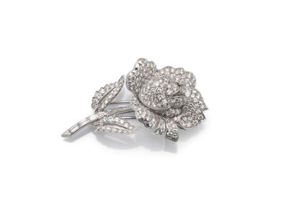 un gros plan d'une broche en forme de fleur sertie de diamants, sur fond blanc
