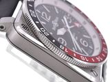a close up of a watch with a black face and red bezel
