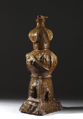 une statue en bronze représentant un homme assis sur une souche d'arbre