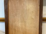an old wooden mirror is sitting on the floor in front of a white wall
