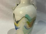 un vase blanc orné d'un motif bleu et jaune
