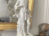 a statue of a woman holding a dog on a table
