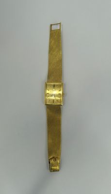 an image of a gold wrist watch on a white surface