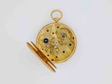 an antique pocket watch with a gold case and a blue stone