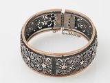 a silver and gold bracelet on a white background