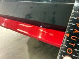 a close up of a red car with a ruler in front of it