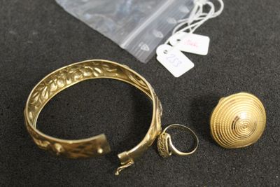 un bracelet, une bague et une boucle d'oreille en or sur un fond noir