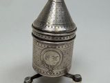 une boîte ancienne en métal argenté, munie d'un couvercle et d'une poignée, posée sur un socle