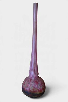 un vase violet posé sur une surface blanche