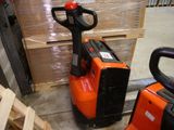 a fork lifter sitting next to a pallet in a warehouse